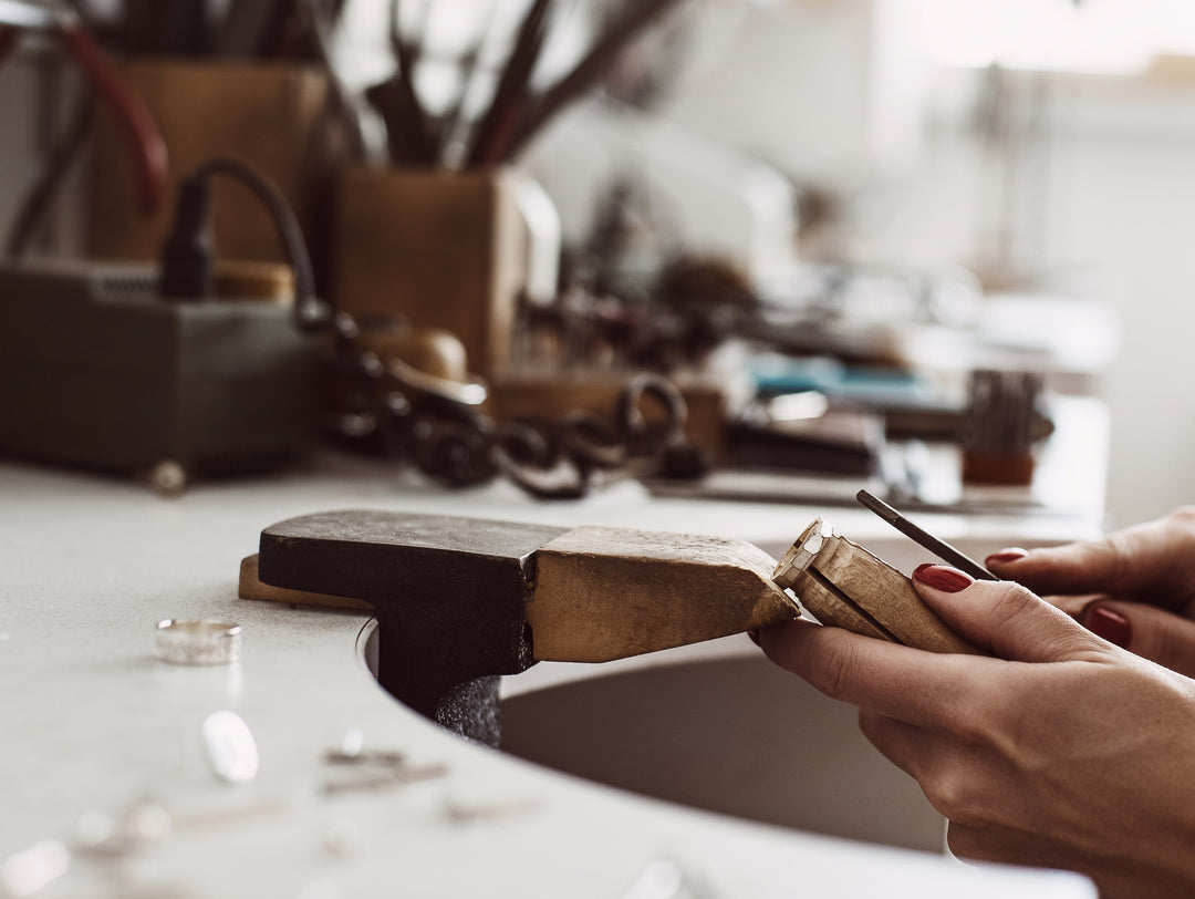 A woman crafting jewellery in a workshop.  