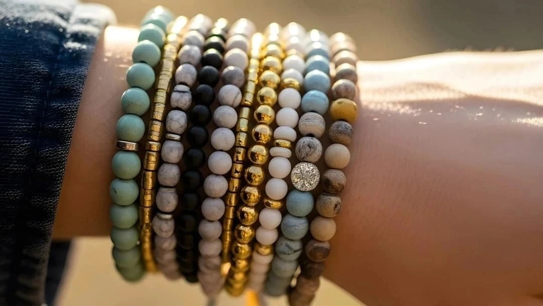 Multiple beaded bracelets on a wrist with a blurred background