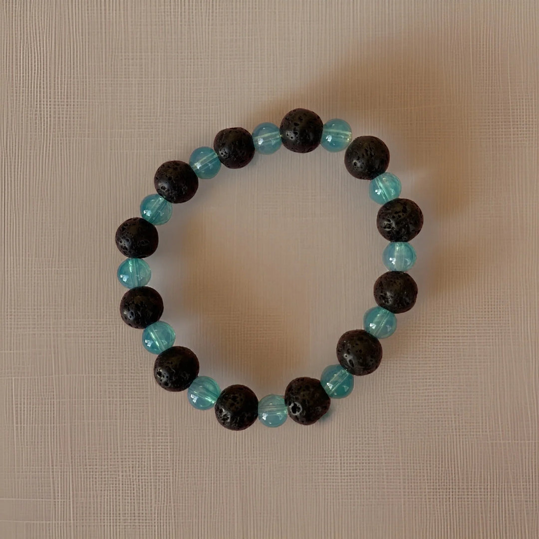 Bracelet with black and turquoise beads on a beige background
