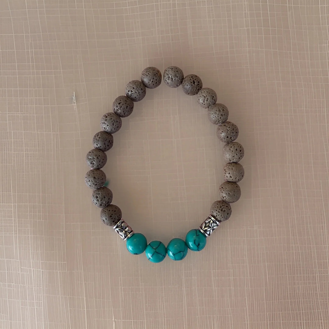Bracelet with gray beads and turquoise accents on a beige background