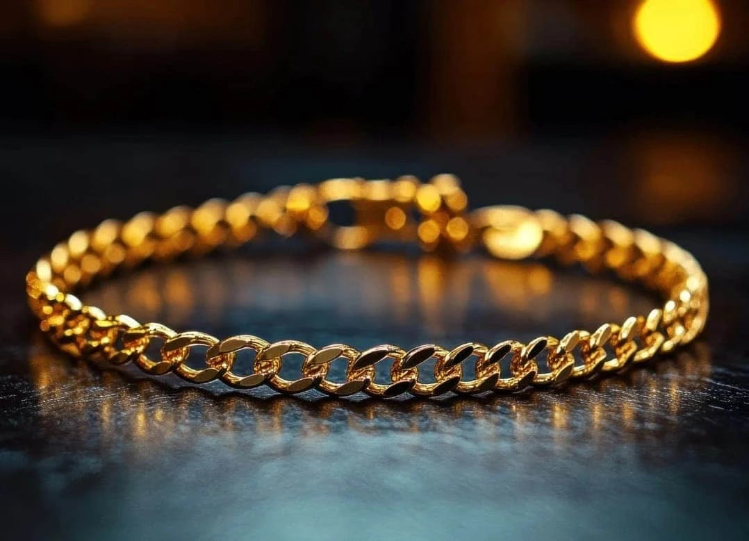 Gold chain bracelet on a dark surface with blurred lights in the background