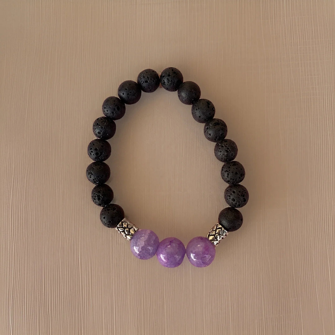 Black beaded bracelet with purple beads on a beige background