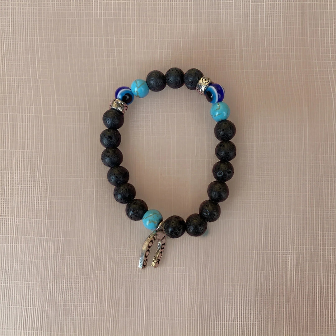 Black beaded bracelet with blue accents on a beige background
